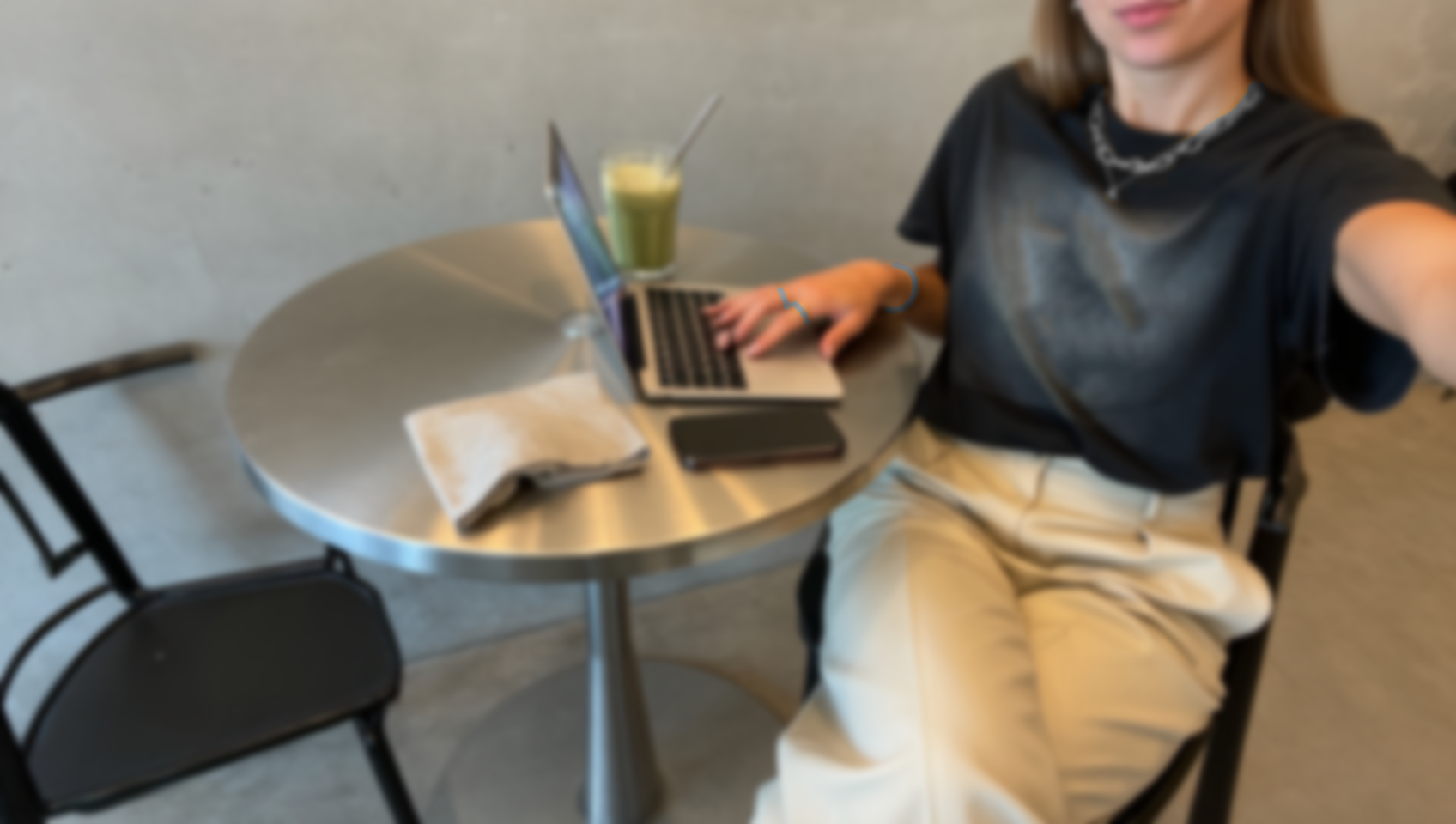 Lena Gireth arbeitet am Laptop an einem Café-Tisch